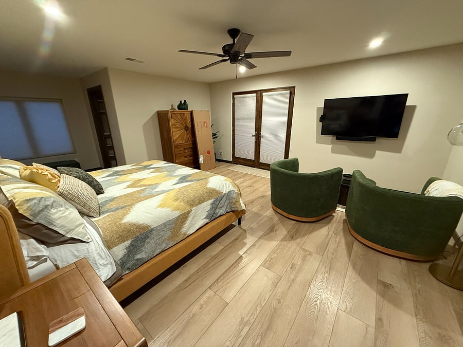 Oversized master bedroom with king bed, smart TV lounge area and private patio.