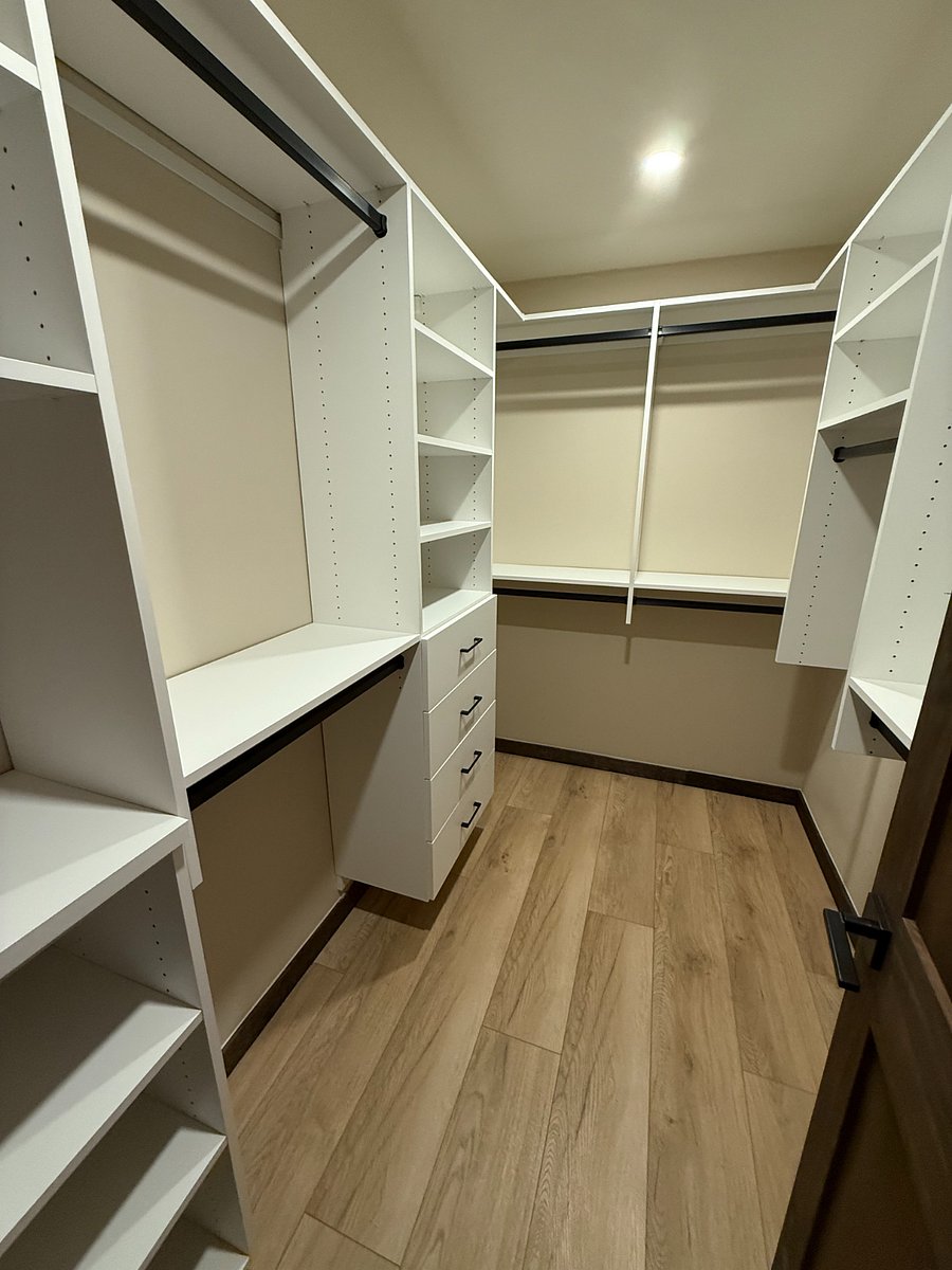 Master bedroom walk-in closet with custom closet system.
