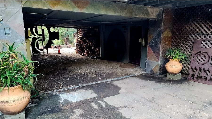 Under house breezeway with EV charger. Lots of art installations.