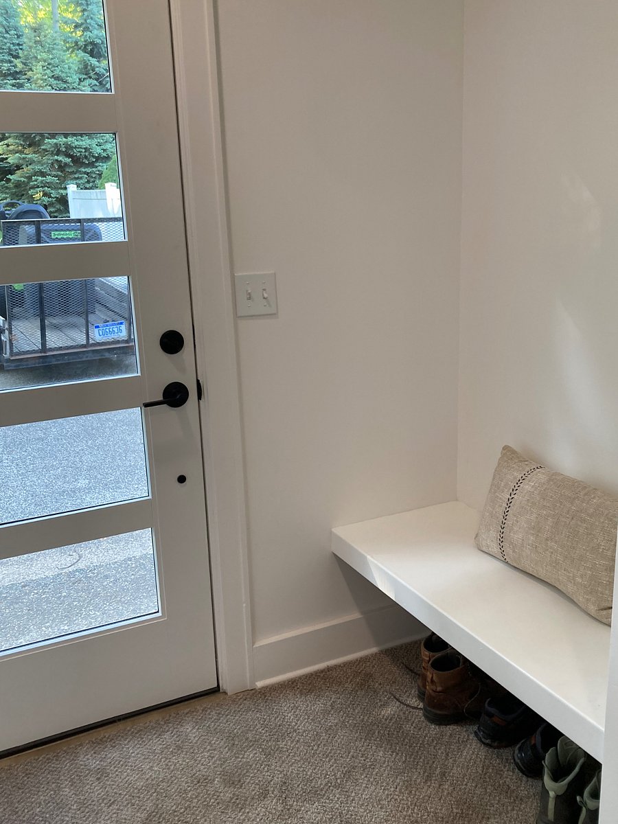 Entryway with bench seating, room for shoes beneath, and hooks to hang a purse or coat/jacket