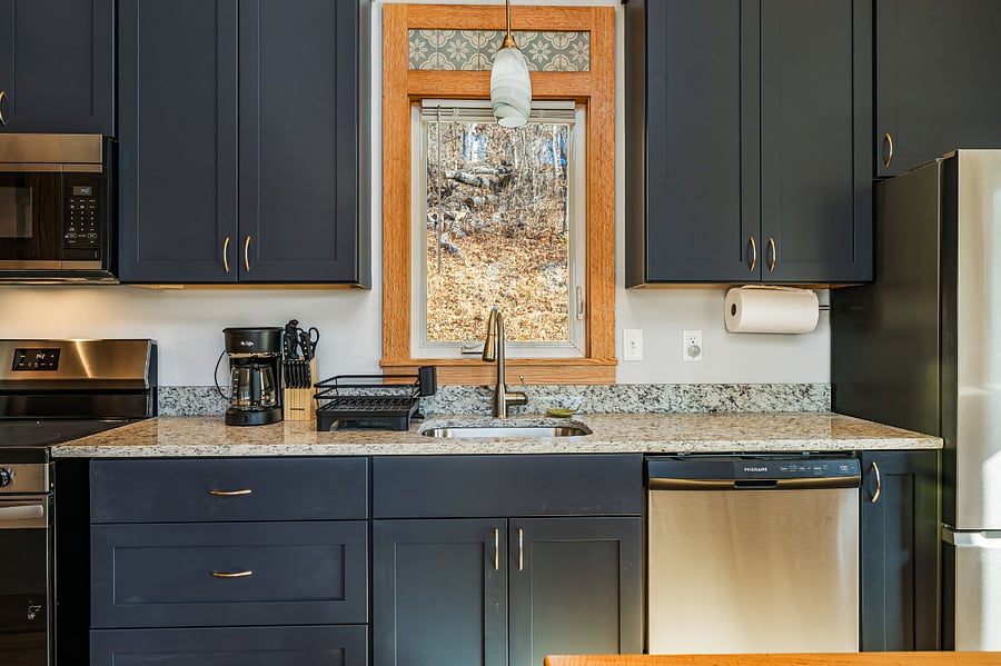 Kitchen contains dishwasher, range, coffee pot, basic cookware, dishes for 4.