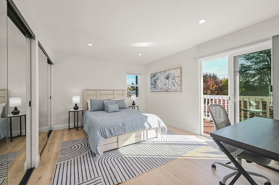 Large primary bedroom with a large closet, a large desk and office chair along with a large deck with seating space 