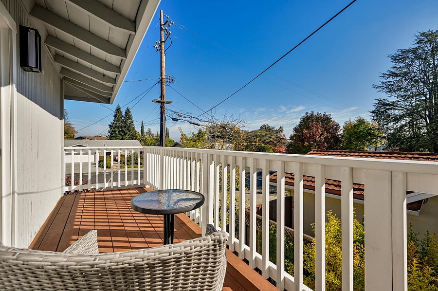 A large deck with seating space right outside of the primary bedroom on the second floor