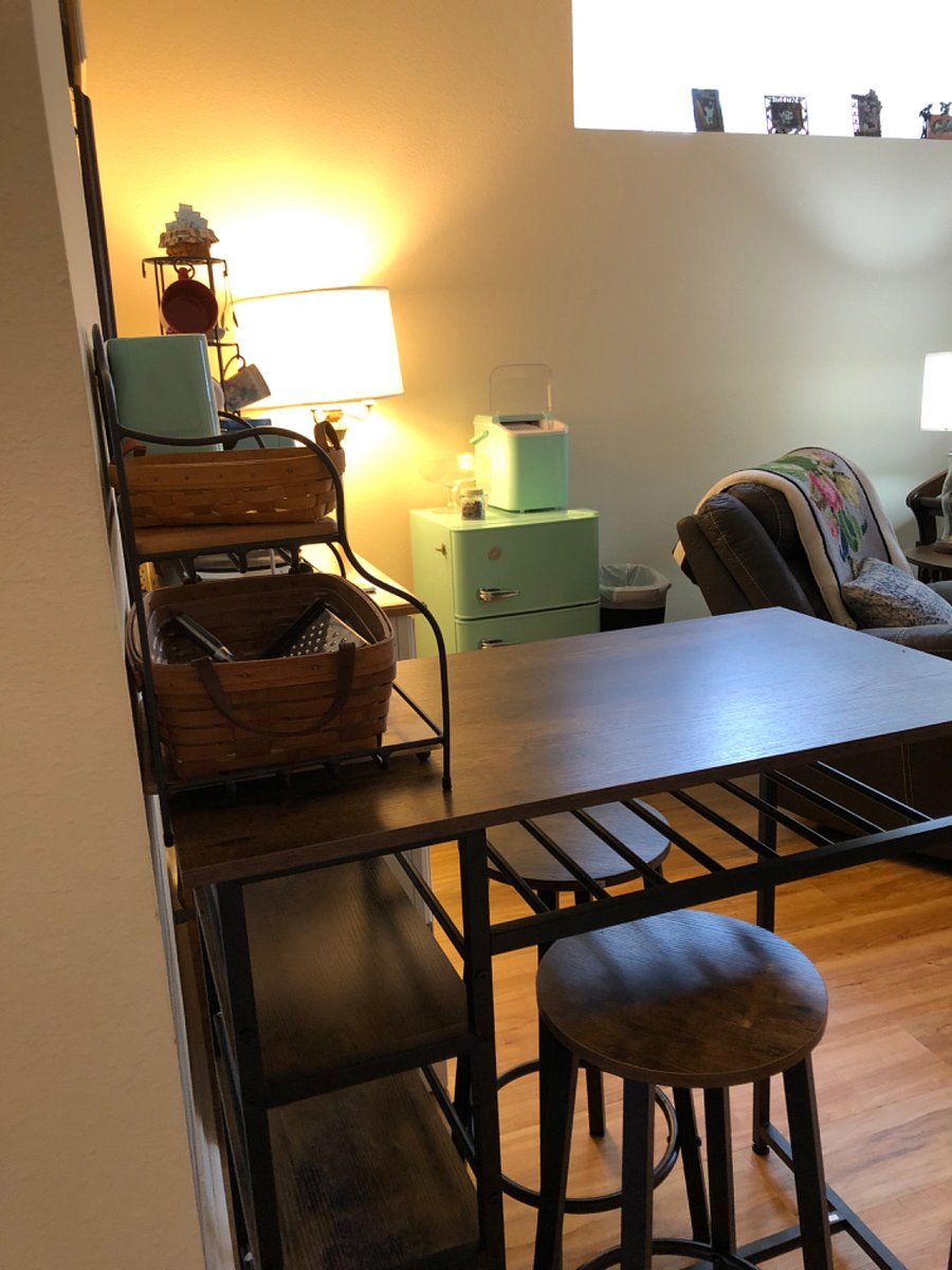 View of table/workstation, recliner and refrigerator.