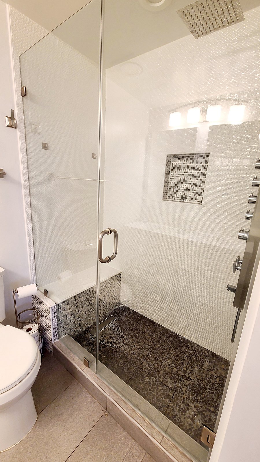 Primary bath includes bench in shower and heavy glass doors