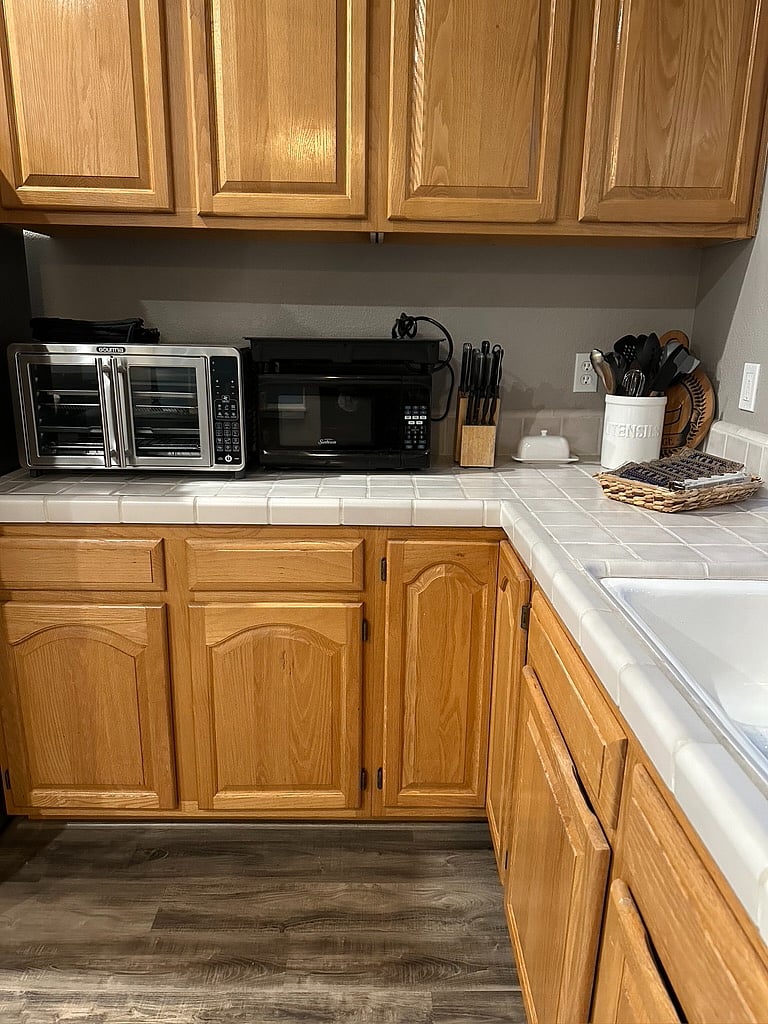 Kitchen with full size fridge, oven/air fryer, michrowave, two-burner countertop cooktop, tea pot, blender, hand mixer, ample counter space and kitchen essentials