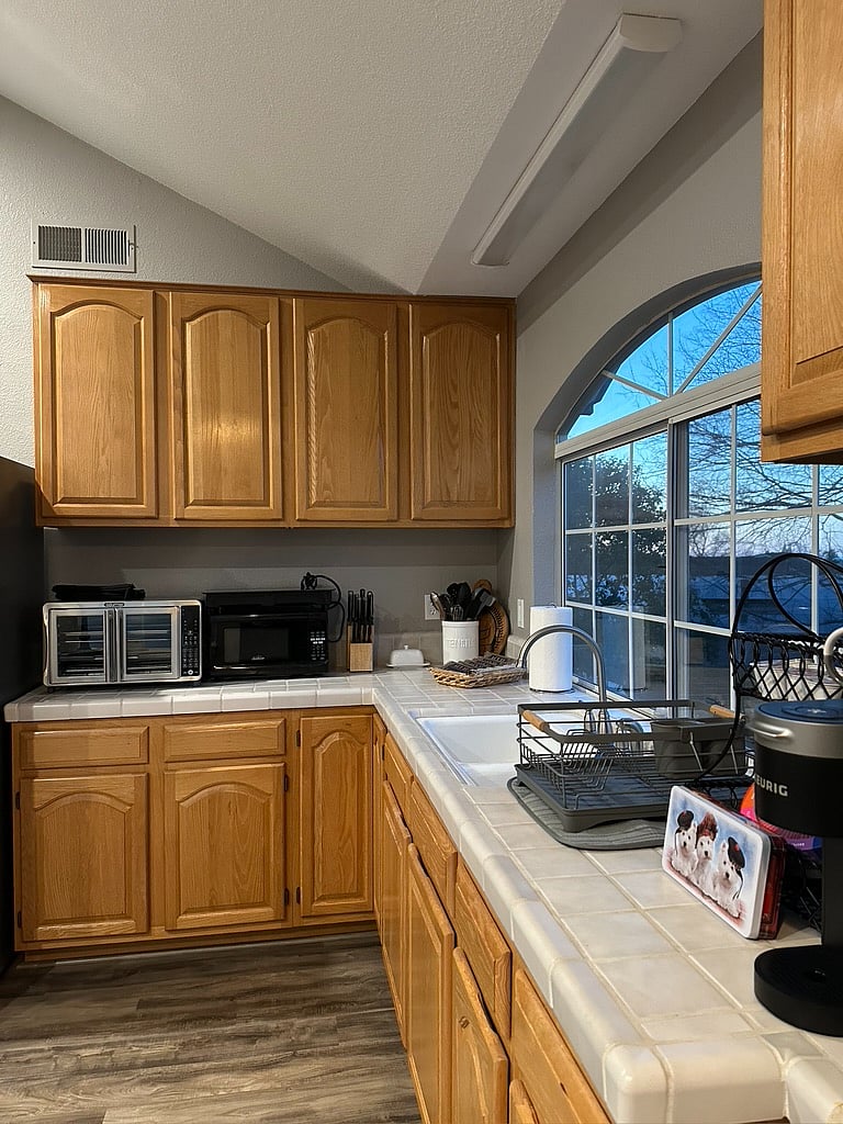 Kitchen with full size fridge, oven/air fryer, michrowave, two-burner countertop cooktop, tea pot, blender, hand mixer, ample counter space and kitchen essentials