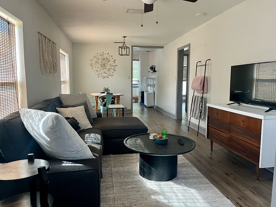 Sunroom leads to living room & dining area - comfy couch, throw blankets, and a smart TV