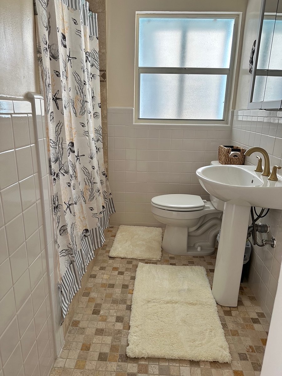 Full bathroom with travertine shower
