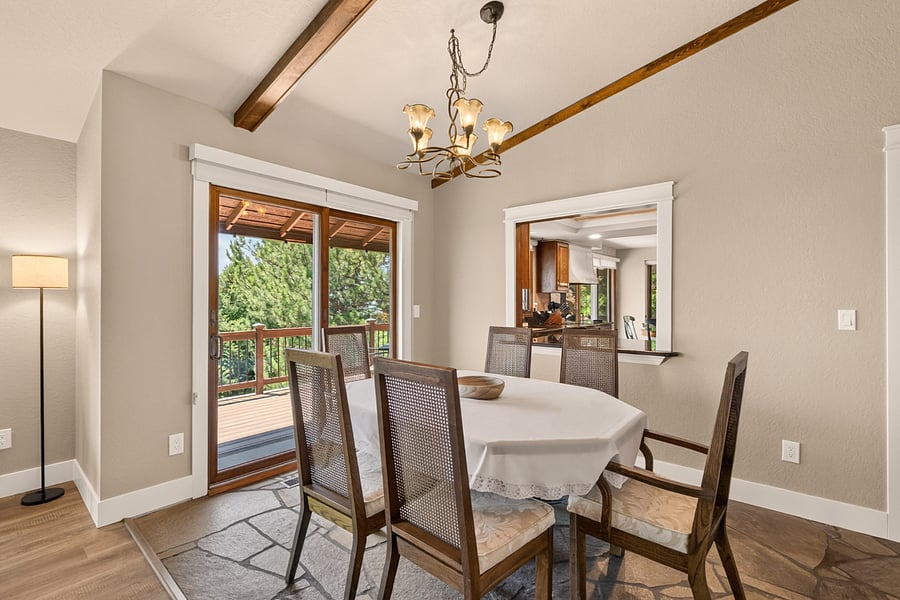 Gather around the dining table for six in this inviting dining room featuring vaulted ceilings with exposed beams, convenient access to the fully equipped kitchen, and sliding glass doors leading to the expansive upper deck. It's the perfect setting for everything from casual breakfasts to holiday dinners and evening entertaining.