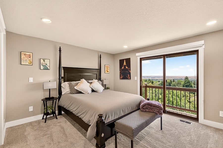 The spacious primary suite on the main level is a peaceful retreat featuring a queen bed, comfortable reading chair, and sliding glass doors that open to a private standing balcony overlooking the Treasure Valley. Start your day with fresh mountain air or unwind in the evening while taking in the panoramic views.