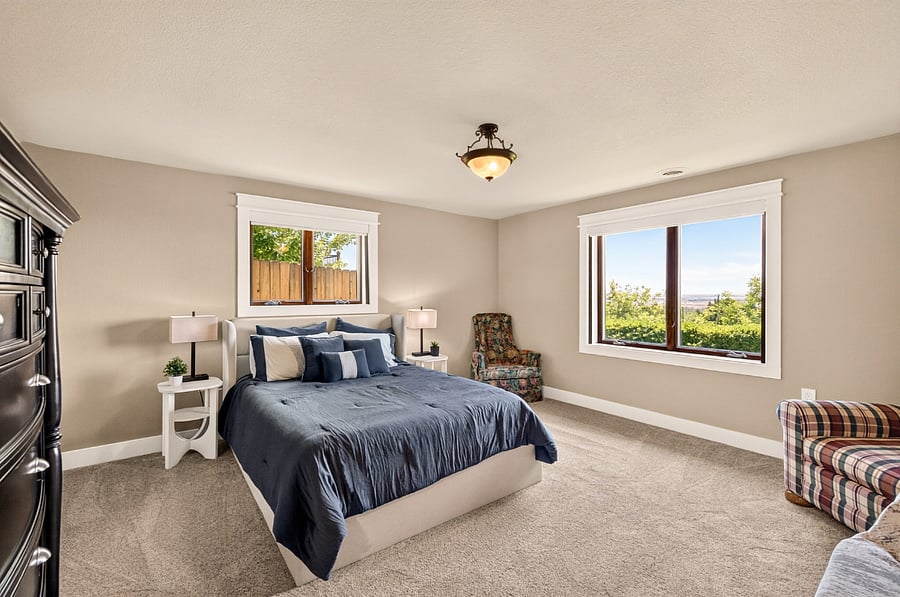 Lower level bedroom 5 with closet, dresser and two upholstered chairs