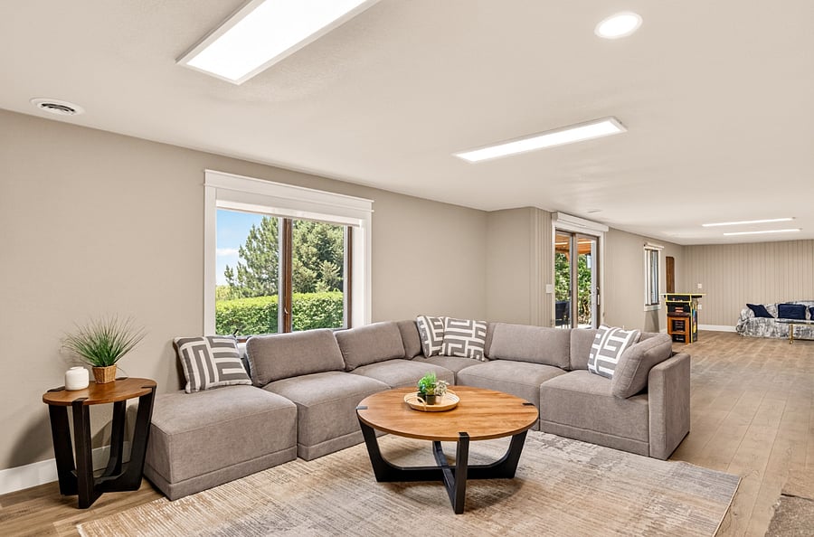 Lower level family room with 75" Samsung smart TV, sectional sofa and fireplace.