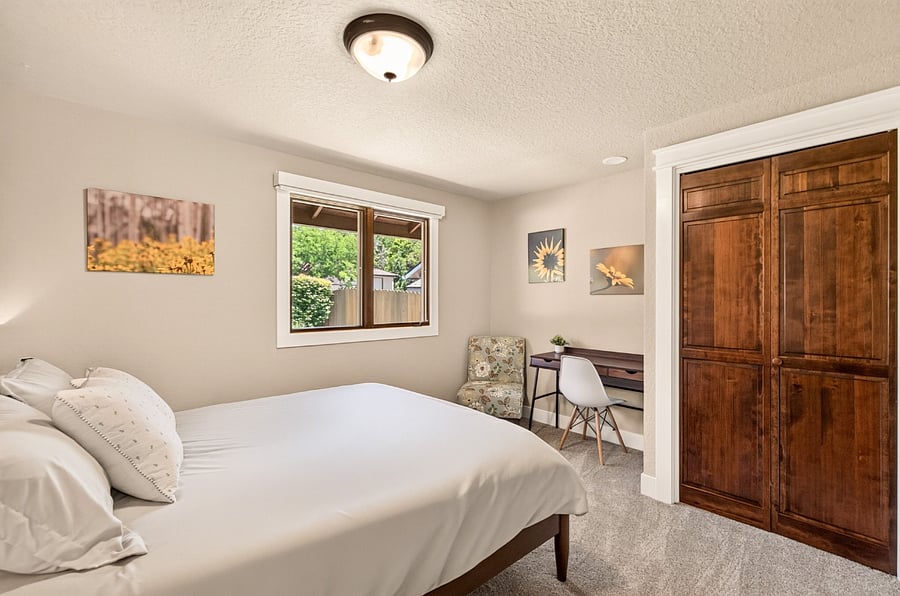 This inviting main-level bedroom features a comfortable queen bed, full closet, and a dedicated writing desk - ideal for remote work or planning the day's adventures. A comfortable upholstered reading chair creates a cozy spot to relax with a book or unwind after a busy day