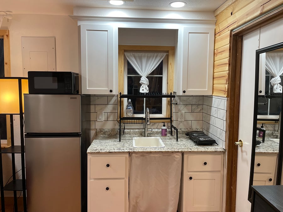 Kitchenette with microwave and stove top burner.