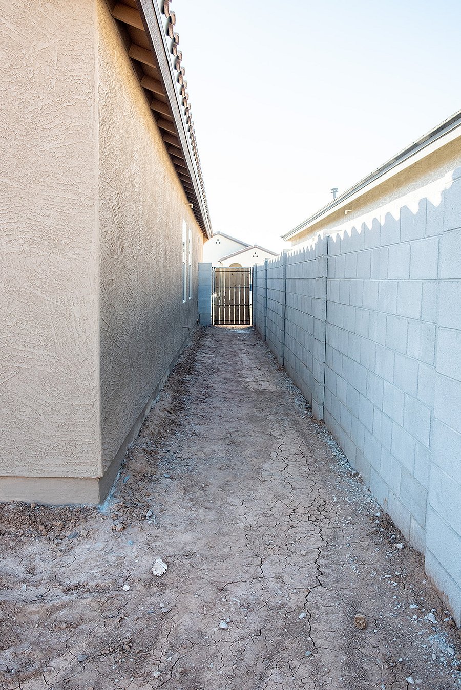sideyard with gate to driveway/ soon to be landscaped