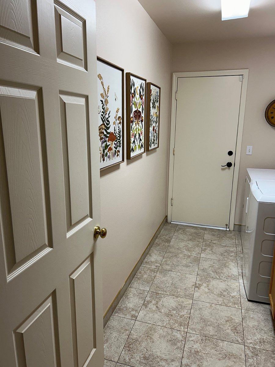 Shared laundry room with lots of counter space, sink, window with lots of natural light, full size washer, full size dryer and door that opens into garage.