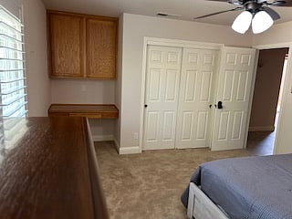 Private bedroom with built in desk, built in closet and remote controlled ceiling fan with dimmable light.