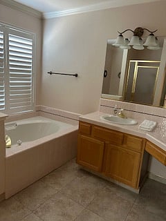 Two sink vanity with lots of counter space, oval tub, shower and window with lots of natural light.