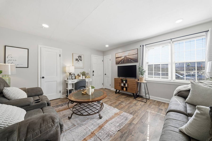 Cozy living room with plush seating, a stylish coffee table, and a smart TV for streaming your favorites. Large windows bring in natural light, creating a bright and comfortable space to relax after a day of exploring.