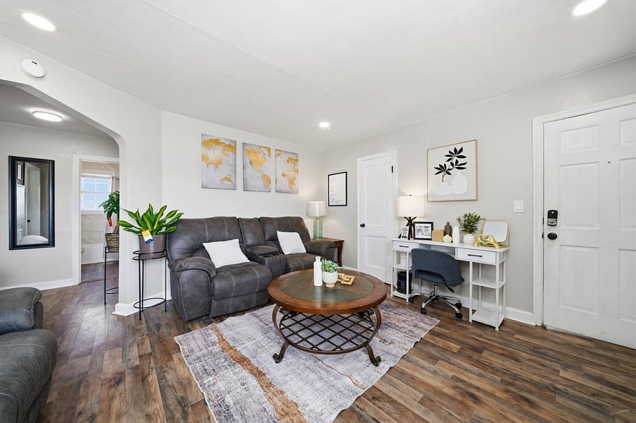 Inviting sitting area with plush reclining seating and stylish dcor throughout. A round coffee table anchors the space, while natural light and warm flooring create a bright, welcoming atmosphere from the moment you arrive.