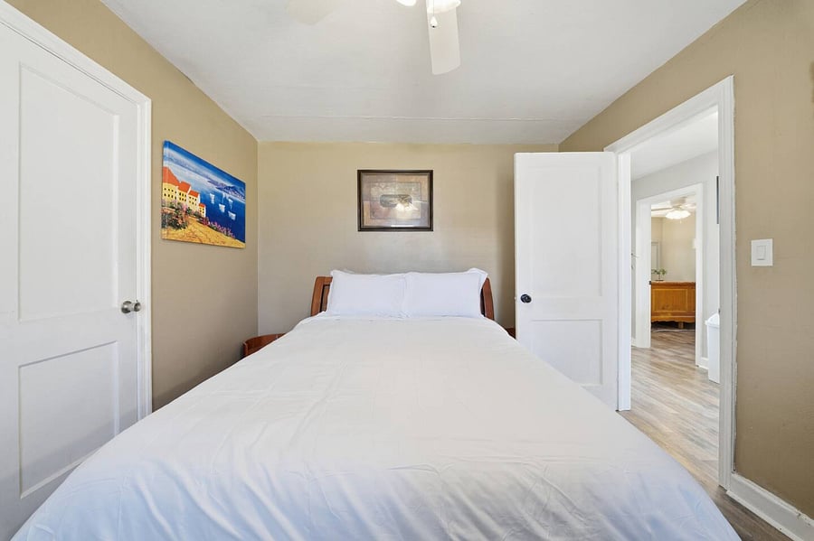 Peaceful bedroom featuring a comfortable bed with crisp linens and plenty of natural light. A small desk by the window offers a quiet spot to work or unwind, while soft tones create a relaxing retreat.