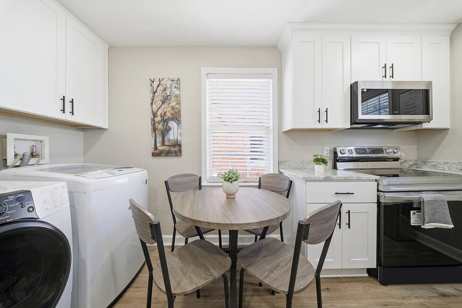 Bright kitchen nook with a cozy round dining table for fourperfect for morning coffee or casual meals. Fully equipped with modern appliances and the convenience of in-unit washer and dryer for a comfortable, home-like stay.