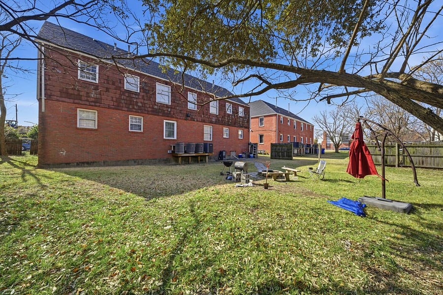 Spacious backyard with a paved walkway and open green space to enjoy the outdoors. A peaceful setting perfect for fresh air, relaxing afternoons, or spending time outside during your stay.