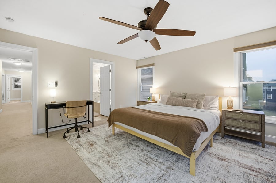 Primary bedroom with ceiling fan and workspace