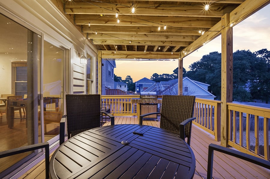 Covered deck with outdoor dining and evening ambiance