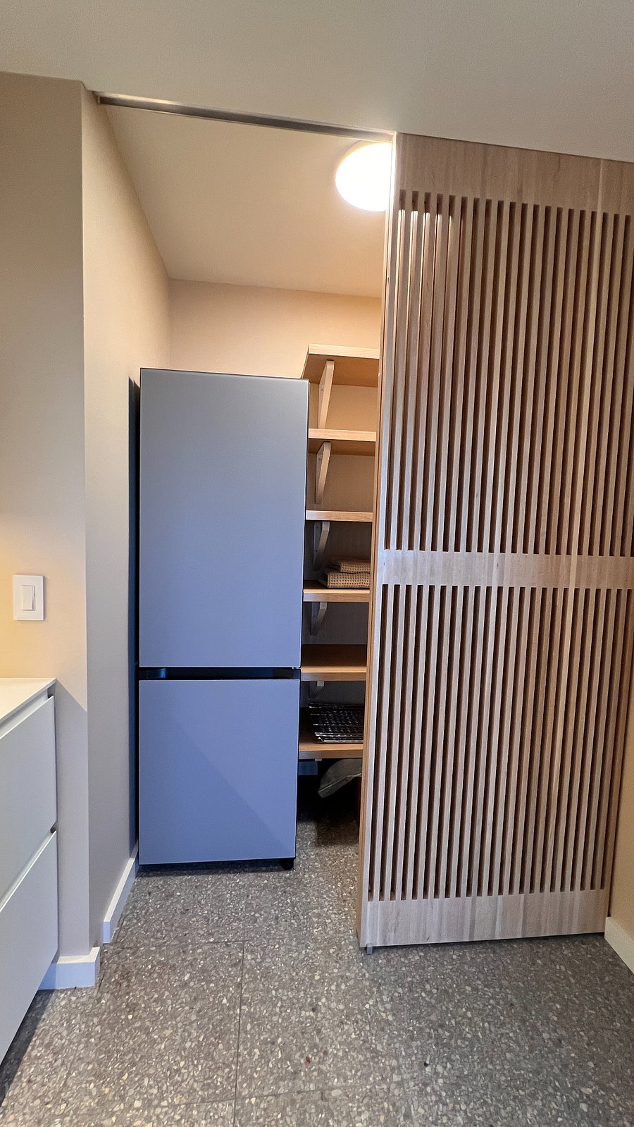 Slatted oak doors conceal pantry and refrigerator