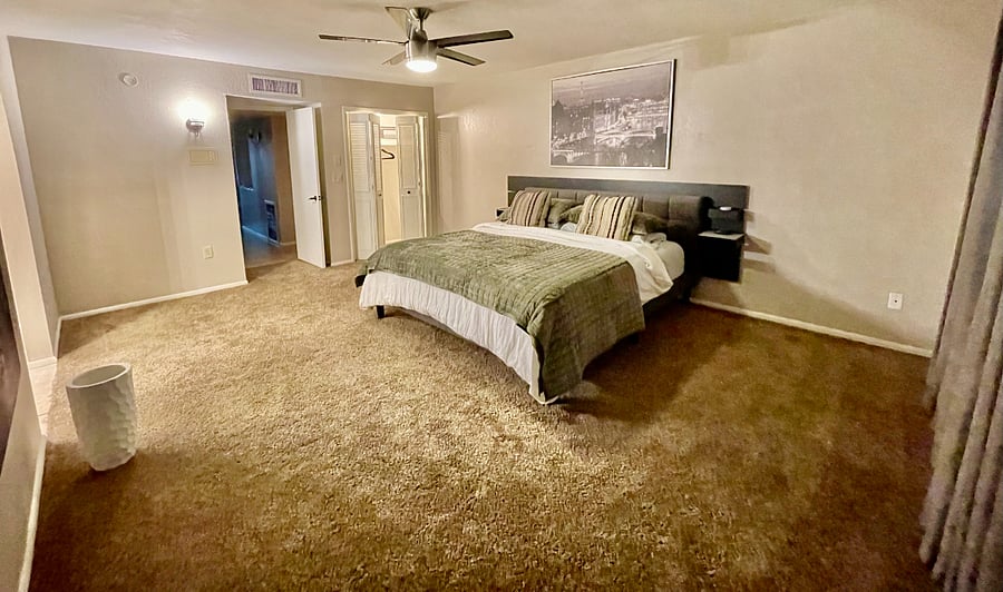 primary bedroom with king bed, en suite bath and small double door closet