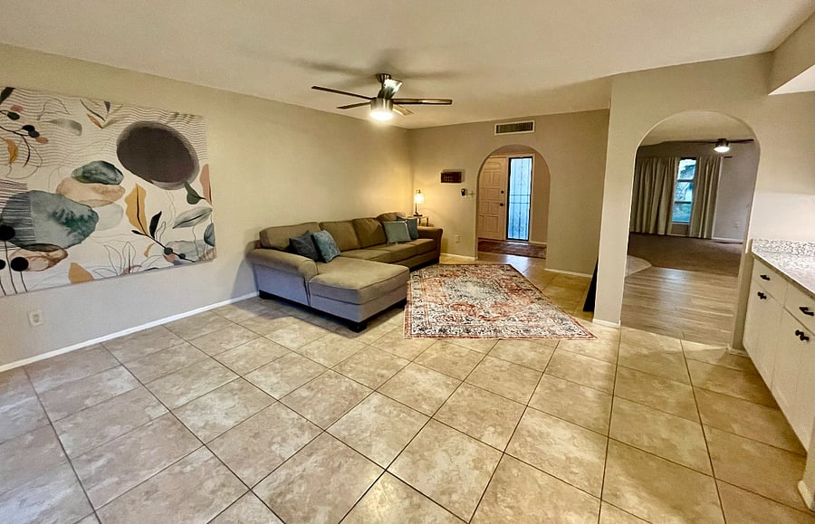 family room off kitchen with small sectional and tv