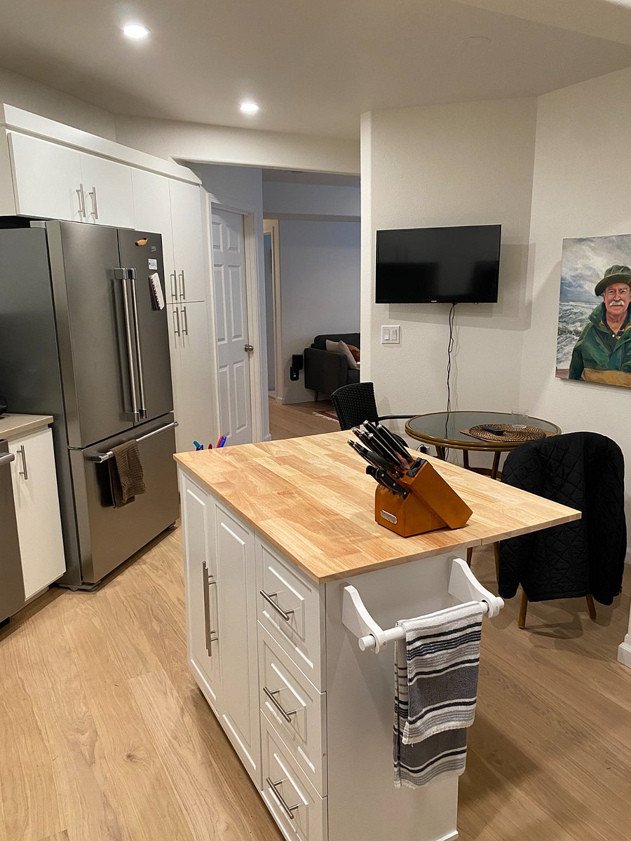 Kitchen island offers ample storage and cooking utensils. Looking into living room.