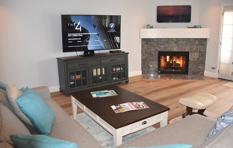 Living area with large smart TV and gas fireplace.
