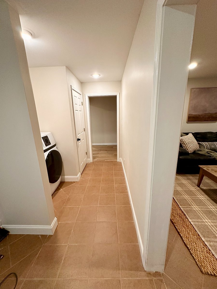 walkway (living room entry on the right, bathroom hallway to the left out of the frame; bed/kitchen areas directly ahead).
