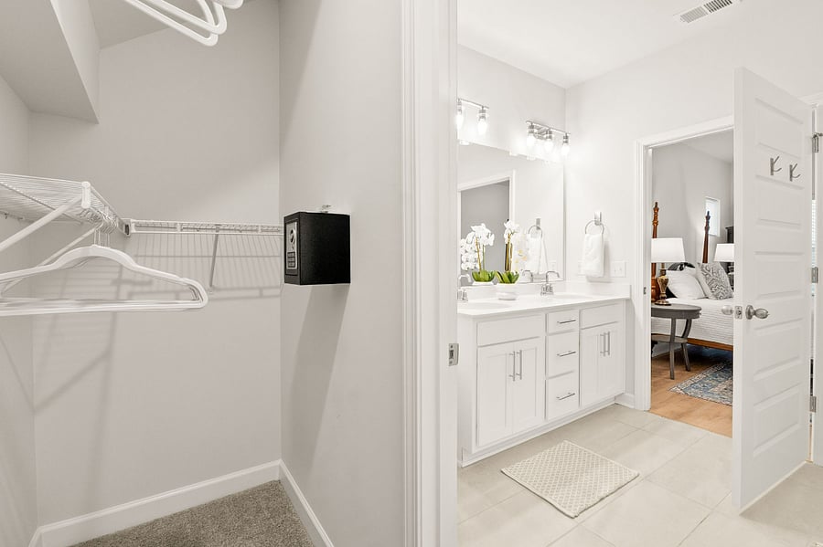 On suite with walk in closet featuring a built in home safe.