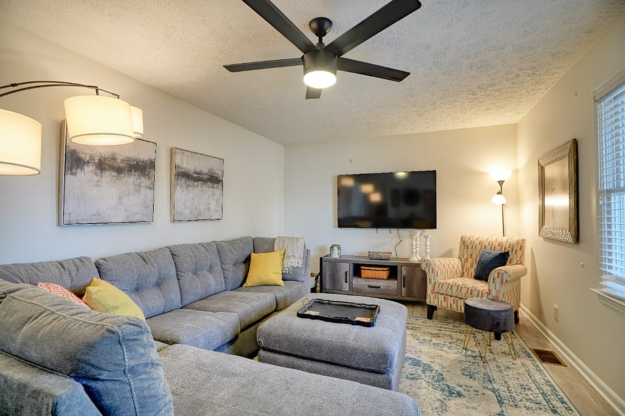 Living room with smart tv and ceiling fan- board games too!
