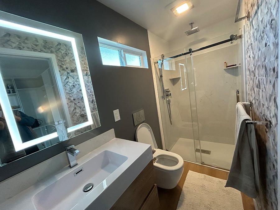 Bath with large recessed medicine cabinet and anti fog adjustable vanity mirror, wall hung toilet and marble lined shower with rain head and adjustable height hand held bar. Programmable underfloor heating.