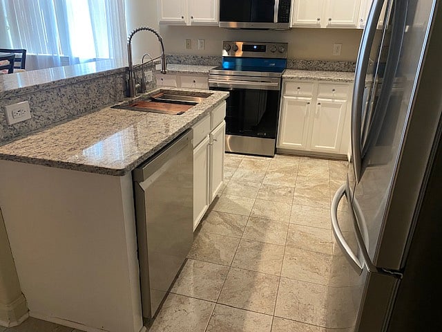 Kitchen with better view of the new workstation sink with dish drainer and cutting board.