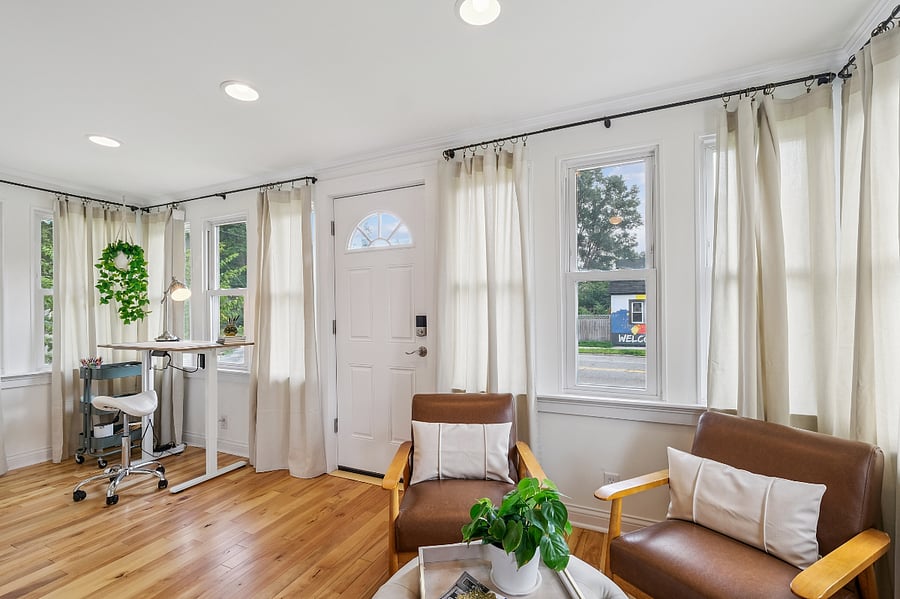 Bright workspace with a sit/stand desk. Additional seating, lounging.