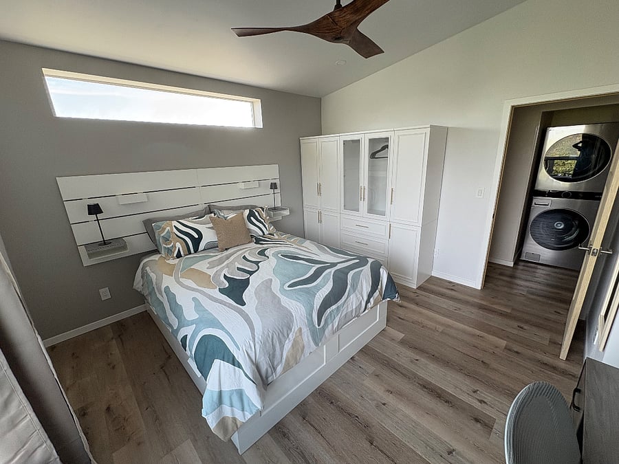 2nd bedroom with stacked washer-dryer in hallway