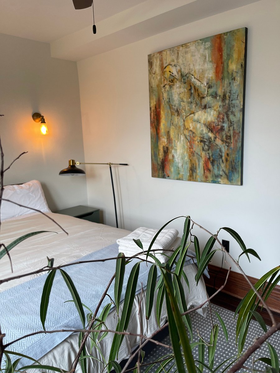 Sunny art and plant-filled second bedroom.