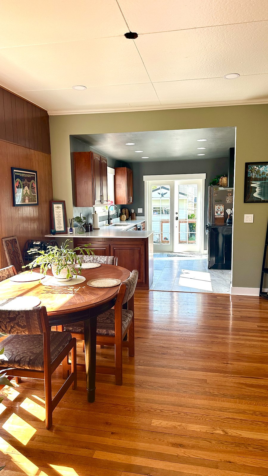 Open concept dining area to kitchen withfrench doors leading to deck, yard, and covered outdoor space.