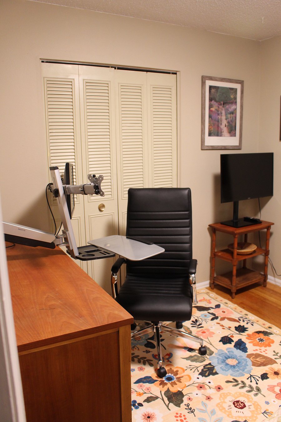 Secondary bedroom desk + monitor. Can be adjusted as a sitting or standing desk, and swivels to the wall when not in use