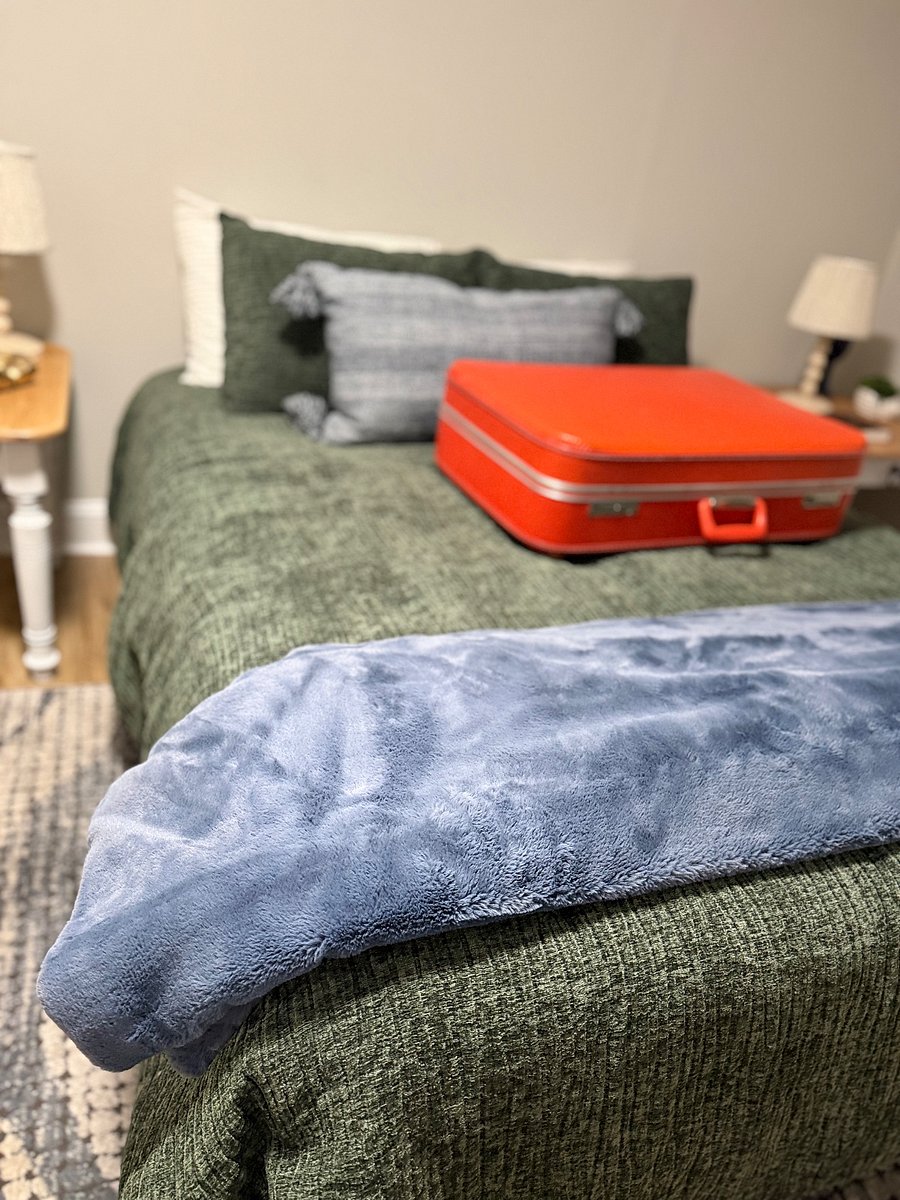 The 3rd bedroom is located upstairs. Queen bed with two night stands and windows and closet.  Night lamps, jewelry and watch holder, ceramic glasses, and journal. Fun items in this room like the orange suitcase. Wood blinds in this room. Adjust as needed.  Dual unit to control the temperature.  Extra linen in the closet. 