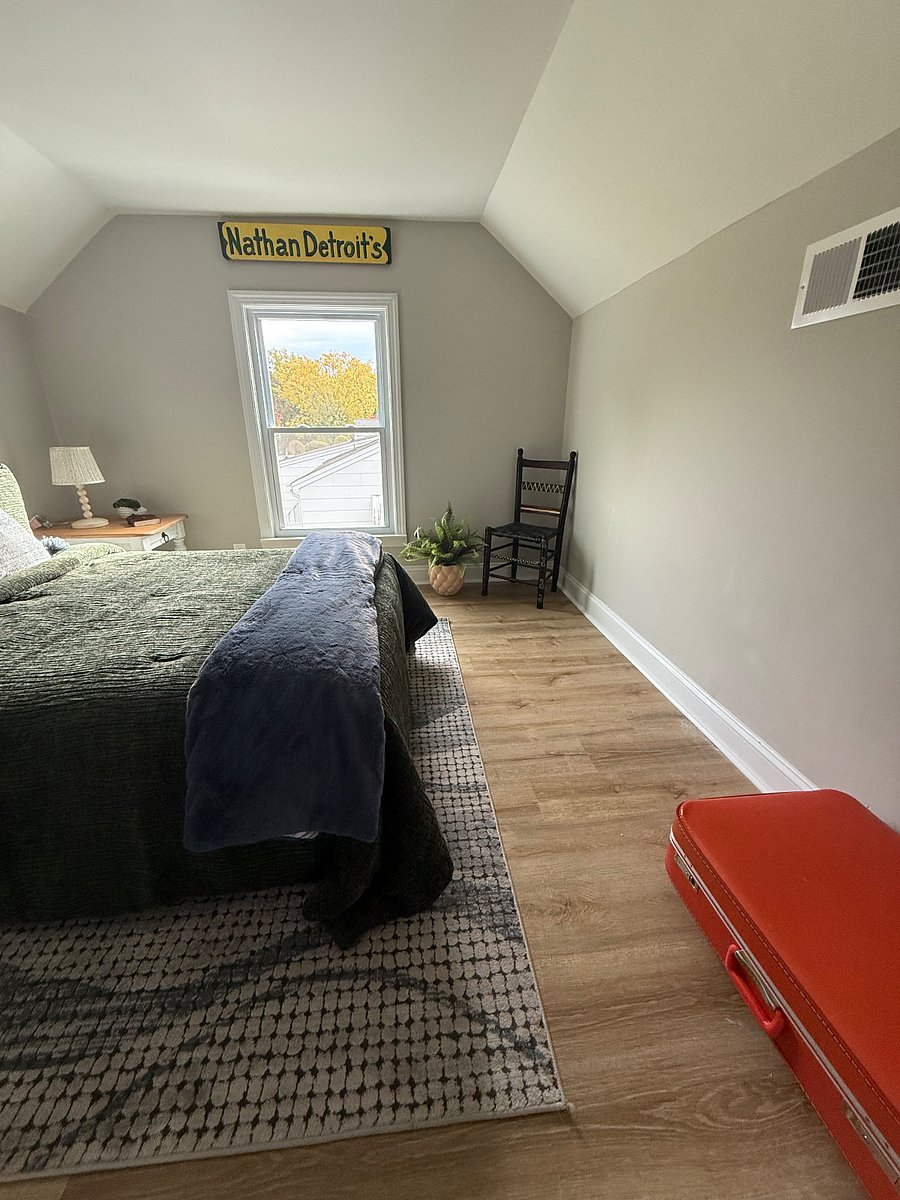 Another angle of the 3rd room upstairs.Queen size bed with 2 farm style tables, lamps, chair for sitting, and window. Closet in room.  