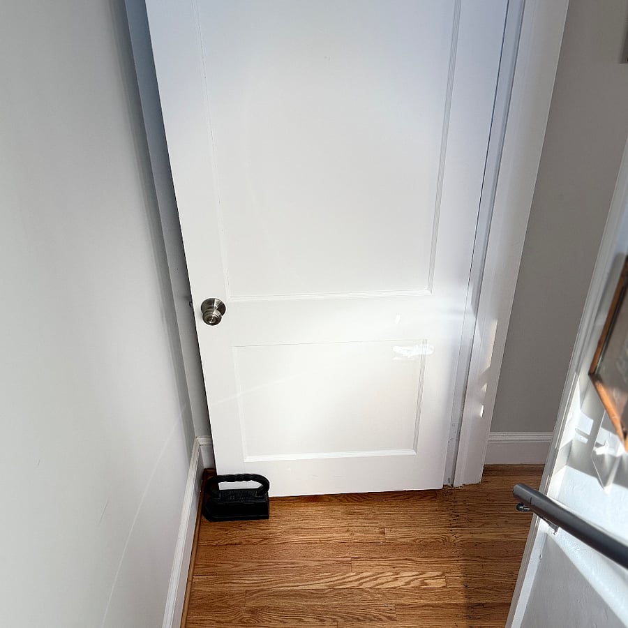 Door to upstairs area.   Weighted IRON as door stopper.  There is a lock on this door in case you don't want use it or extra guests are upstairs and does not want to come downstairs if there is company in the house.  They can still enter the kitchen. 