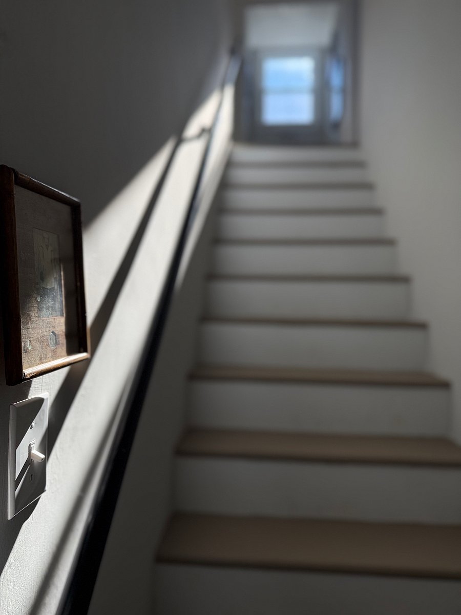 Upstairs with wood rail.  About 12 steps.  Beautiful view upstairs with a seating area. and nice artwork.   