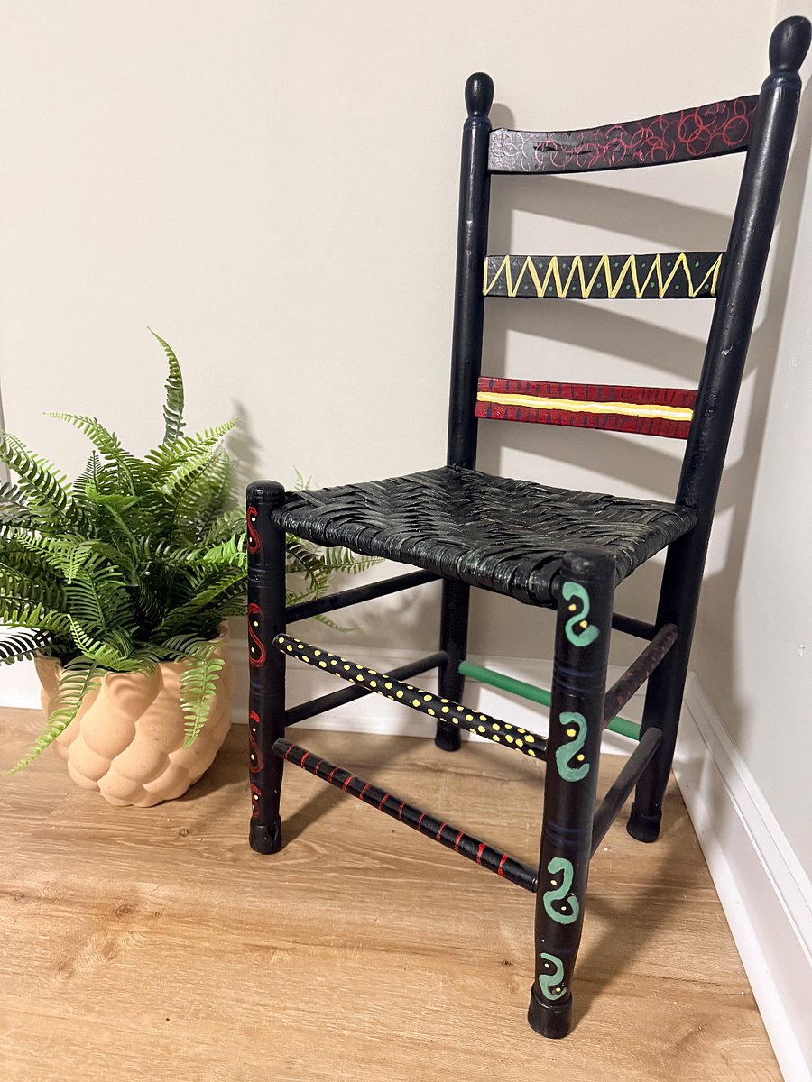 3rd bedroom upstairs.  Sitting chair and artificial plant.    The chair is designed by a local artist in Winston Salem who died at 92.